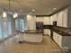 Open kitchen with white cabinets, granite countertops, stainless appliances, and a central island at 10715 Tom Short Rd, Charlotte, NC 28277