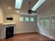 Bright living room with a fireplace, skylights and modern ceiling fan, offering great natural light at 10715 Tom Short Rd, Charlotte, NC 28277