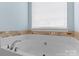 Bright bathroom features a large soaking tub with tile surround and a window with natural light at 108 Planters Dr, Statesville, NC 28677