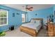 Cozy bedroom with a wooden bed frame, ceiling fan, and two windows for ample natural light at 108 Planters Dr, Statesville, NC 28677