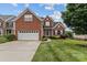 Charming two-story brick home with an attached garage and well-manicured lawn at 108 Planters Dr, Statesville, NC 28677