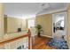 Upstairs hallway with hardwood floors, a staircase and a view into an adjacent bedroom at 108 Planters Dr, Statesville, NC 28677