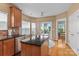 Eat-in kitchen features an island, wood floors, stainless steel appliances, and access to the backyard at 108 Planters Dr, Statesville, NC 28677