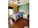 Bedroom with dark wood floors, a ceiling fan, a side table, and a full-size bed with a turquoise accent wall at 111 Brookview Dr, Shelby, NC 28152
