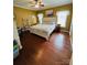Bedroom with dark wood floors, a ceiling fan, and a queen-size bed with a white frame and floral bedding at 111 Brookview Dr, Shelby, NC 28152