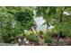 Lakeside backyard showcasing a stone patio, fire pit, and dock access, surrounded by lush greenery and mature trees at 1111 Palmyra Dr, Fort Mill, SC 29708