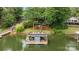 Aerial view of a private boat dock with boat lift on a serene lake, surrounded by lush greenery at 1111 Palmyra Dr, Fort Mill, SC 29708