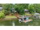 Scenic view of a private boat dock with boat lift on a serene lake, surrounded by lush greenery and well-kept lawns at 1111 Palmyra Dr, Fort Mill, SC 29708