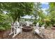 Inviting stone patio features a cozy fire pit surrounded by Adirondack chairs, perfect for lakeside relaxation at 1111 Palmyra Dr, Fort Mill, SC 29708