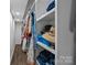 Well-organized walk-in closet with shelving filled with clothing, hats and storage bins on wood floors at 1111 Palmyra Dr, Fort Mill, SC 29708