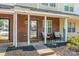 Welcoming brick front porch with cozy seating and nicely landscaped garden beds at 11218 Grass Field Rd # 1083, Charlotte, NC 28213