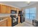 Functional kitchen with wood cabinets, black appliances, and natural light at 11218 Grass Field Rd # 1083, Charlotte, NC 28213