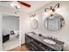 Bathroom with dual sinks on a black vanity, ceiling fan, and mirrors at 11714 Harsworth Ln, Charlotte, NC 28277