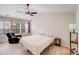Bright bedroom with a ceiling fan, chair, and large windows with views of the outdoors at 11714 Harsworth Ln, Charlotte, NC 28277