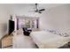 Spacious bedroom with a ceiling fan, television and multiple windows providing plenty of natural light at 11714 Harsworth Ln, Charlotte, NC 28277