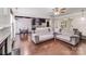 Inviting living room with hardwood floors, a ceiling fan, and an open floor plan to the kitchen at 11714 Harsworth Ln, Charlotte, NC 28277