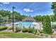 Community pool with ample lounge chairs and a beautiful clubhouse in a lush, landscaped setting at 11714 Harsworth Ln, Charlotte, NC 28277