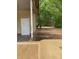 Exterior view of the home's side entrance with a concrete patio, siding, and natural landscape at 120 Booker St, Wingate, NC 28112