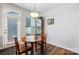Cozy breakfast nook with a wooden table and chairs next to a door and a window with blinds at 1201 Township Pkwy, Belmont, NC 28012