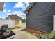 View of the side of the home with gray siding and a concrete patio at 1201 Township Pkwy, Belmont, NC 28012