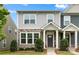 Close up exterior shot of a gray two-story townhome featuring stone accents and a manicured lawn at 1201 Township Pkwy, Belmont, NC 28012