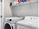 Bright laundry area with white washer and dryer, plus shelving for storage at 1201 Township Pkwy, Belmont, NC 28012