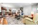 Bright, open-concept living room featuring a dining area and kitchen with warm wood floors and a stylish rug at 1201 Township Pkwy, Belmont, NC 28012