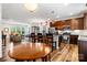 Open-concept living space with a kitchen, dining area, and living room featuring hardwood floors and ample light at 1201 Township Pkwy, Belmont, NC 28012