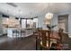 Open concept featuring a large wooden dining table adjacent to a modern kitchen with white cabinets at 1284 Independence St, Fort Mill, SC 29708