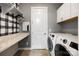 Well-lit laundry room with white cabinets, countertop, and modern washer-dryer for convenient chores at 1284 Independence St, Fort Mill, SC 29708