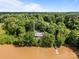 Expansive aerial view of a secluded home surrounded by dense trees near a serene river and private dock at 1433 Kern Carlton Rd, Salisbury, NC 28146