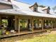 Front exterior featuring a wraparound porch, rocking chairs, and beautiful landscaping, welcoming entry at 1433 Kern Carlton Rd, Salisbury, NC 28146