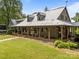Charming home with a metal roof and a spacious wraparound porch featuring rocking chairs at 1433 Kern Carlton Rd, Salisbury, NC 28146