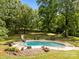 Backyard pool area with a slide, lounge chairs, and mature trees for shade and privacy at 1433 Kern Carlton Rd, Salisbury, NC 28146