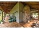 Covered porch featuring a stone fireplace, outdoor seating, and wood flooring, ideal for entertaining at 1433 Kern Carlton Rd, Salisbury, NC 28146