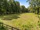 Large grassy yard with mature trees and a wooden fence, offering privacy and space at 1433 Kern Carlton Rd, Salisbury, NC 28146