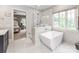 Luxurious bathroom featuring a standalone tub, glass shower, and bright natural light at 1600 Princeton Ave, Charlotte, NC 28209