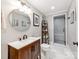 Modern bathroom boasts a vanity with a round mirror, stylish lighting, and glass-enclosed shower at 1600 Princeton Ave, Charlotte, NC 28209