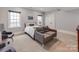 Bright, carpeted bedroom featuring two windows, a loveseat, and neutral decor at 1600 Princeton Ave, Charlotte, NC 28209