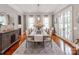 Elegant dining room featuring a large table, wood floors, and bright windows covered in sheer white curtains at 1600 Princeton Ave, Charlotte, NC 28209