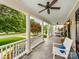 Spacious front porch with classic columns, a porch swing, comfortable seating, and stylish flooring at 1600 Princeton Ave, Charlotte, NC 28209