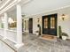 Charming front porch with classic columns, a ceiling fan, double doors, and stylish tile flooring at 1600 Princeton Ave, Charlotte, NC 28209