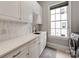 Bright laundry room with white cabinetry, quartz counters and window views at 1600 Princeton Ave, Charlotte, NC 28209