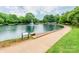 Peaceful pond view with a water fountain, a paved walkway, and trees in a tranquil neighborhood park at 1600 Princeton Ave, Charlotte, NC 28209