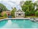 Gorgeous backyard pool and pavilion with seating, lush landscaping, and serene atmosphere at 1600 Princeton Ave, Charlotte, NC 28209