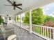 Inviting covered porch featuring gray flooring, white railings, and a relaxing seating area at 1600 Princeton Ave, Charlotte, NC 28209