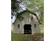 A barn with exterior siding, offering a rustic look, and is surrounded by lush greenery and mature trees at 1614 Statesville Blvd, Salisbury, NC 28144