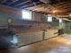 Basement featuring concrete walls and floors, exposed ceilings, and built-in shelving and cabinet storage at 1614 Statesville Blvd, Salisbury, NC 28144