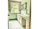 Bright bathroom featuring updated tilework, vanity with built in make up table and natural light at 1614 Statesville Blvd, Salisbury, NC 28144