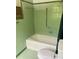 A clean, retro green bathroom features a soaking tub with shower and classic tilework throughout at 1614 Statesville Blvd, Salisbury, NC 28144